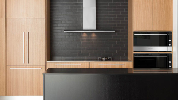 Modern Kitchen featuring Stainless Steel Backsplash, Granite Countertop, Espresso Coffee Maker atop a Black Glass Induction Cooktop and an Integrated Range Hood. 